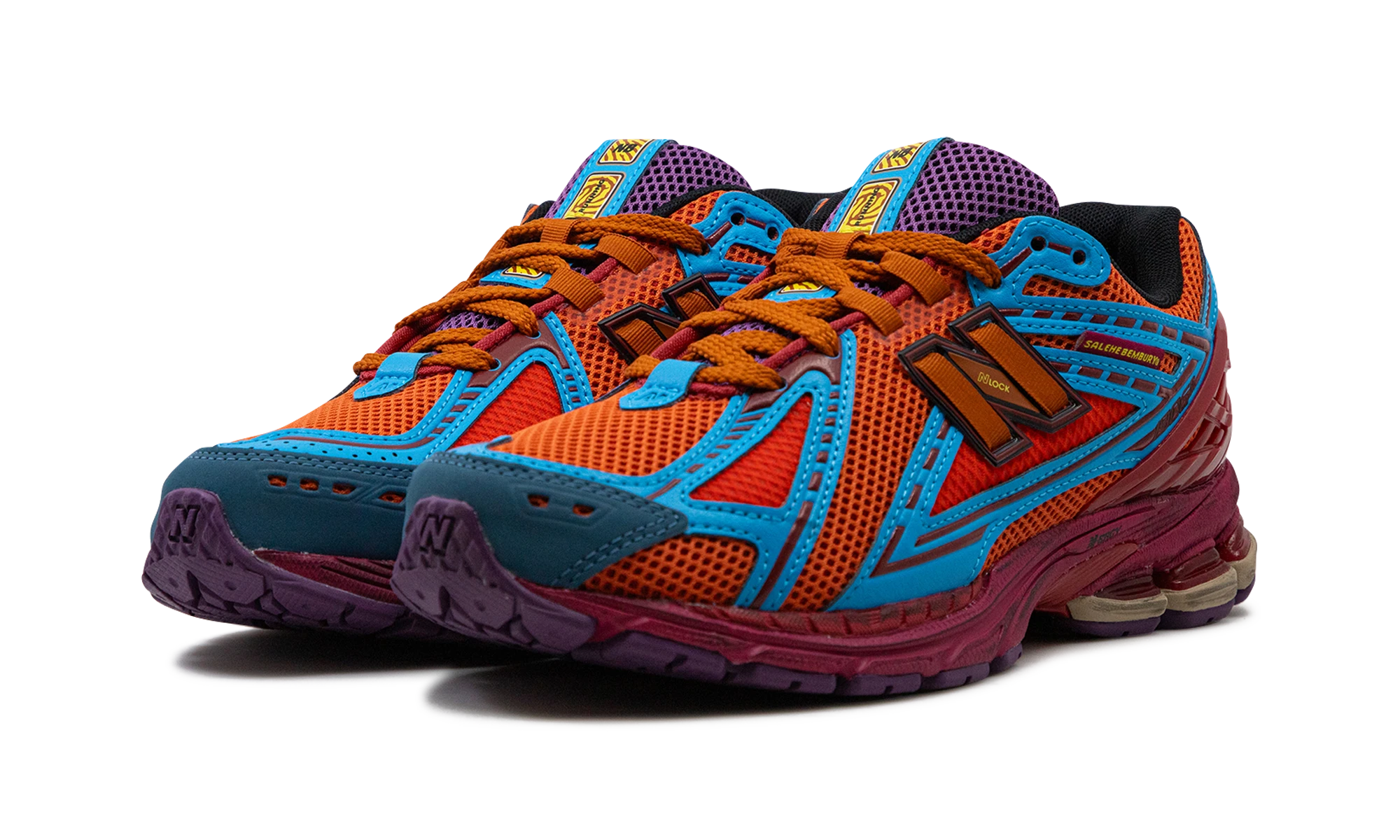Vue de face de la paire de sneakers New Balance 1906R Salehe Bembury Heat Be Hot Magma orange, rouge et bleu.